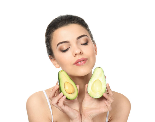Schöne junge Frau mit Avocado auf weißem Hintergrund - Foto, Bild