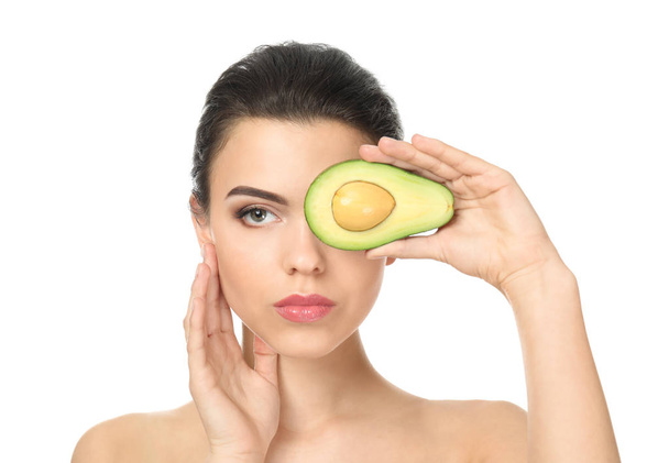 Beautiful young woman with avocado on white background - Photo, Image