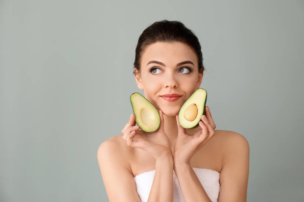 Beautiful young woman with avocado on color background - Fotoğraf, Görsel