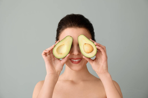 Funny young woman with avocado on color background - Photo, Image