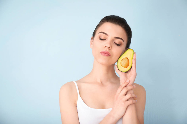 Красива молода жінка з авокадо на кольоровому фоні
 - Фото, зображення