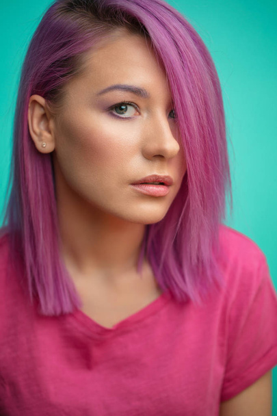 Attractive female with pink hair, stylish haircut, dressed in pink t-shirt, closeup - Фото, зображення