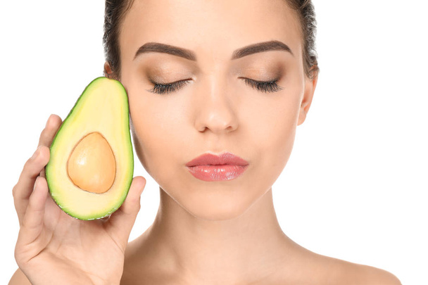 Beautiful young woman with avocado on white background - Фото, изображение
