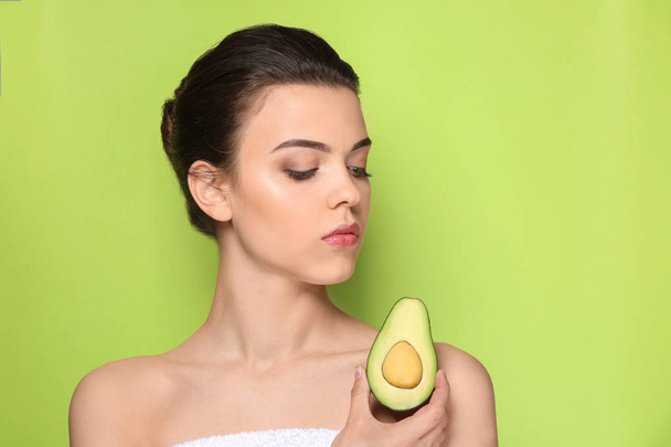Красивая молодая женщина с авокадо на цветном фоне
 - Фото, изображение