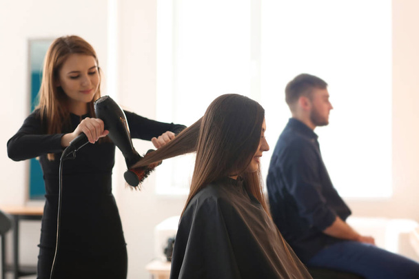 Professioneller Friseur arbeitet mit Klient im Salon - Foto, Bild