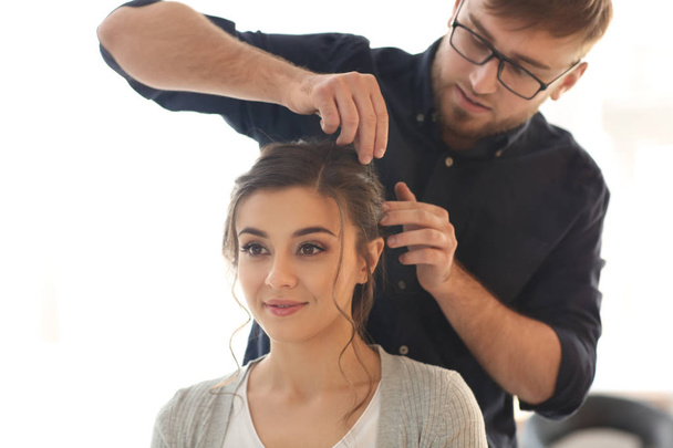 Профессиональный парикмахер работает с клиентом в салоне
 - Фото, изображение