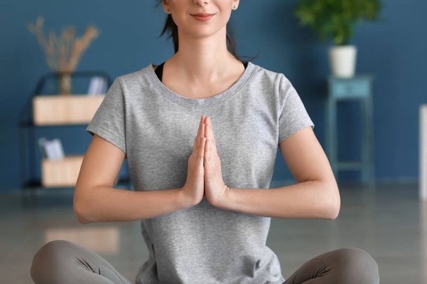 Junge Frau praktiziert Yoga im Haus - Foto, Bild