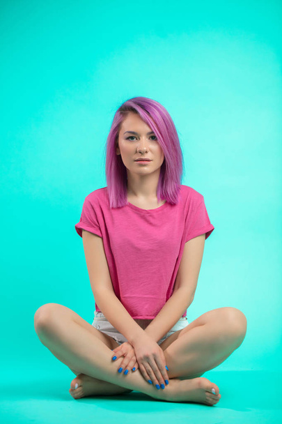 Student sitting in the studio. Young girl with straight pink hair sitting on the floor. - Fotoğraf, Görsel