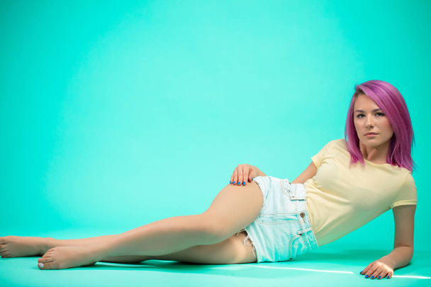 Young woman sitting on the floor isolated - Photo, image