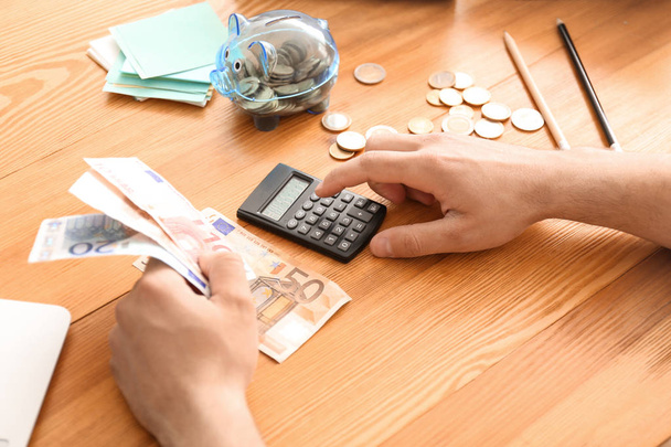 Jeune homme comptant l'argent à table, gros plan
 - Photo, image