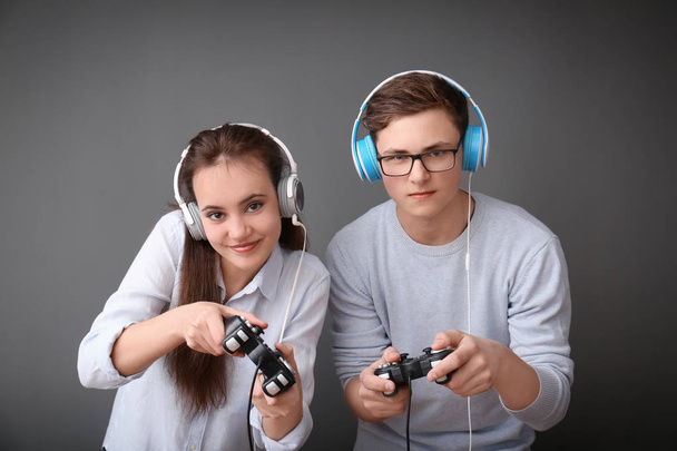 Adolescentes com gamepads em fundo cinza
 - Foto, Imagem