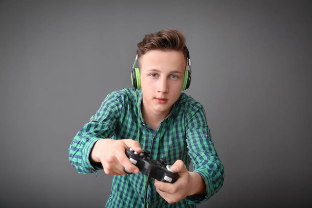 Adolescente com gamepad em fundo cinza
 - Foto, Imagem