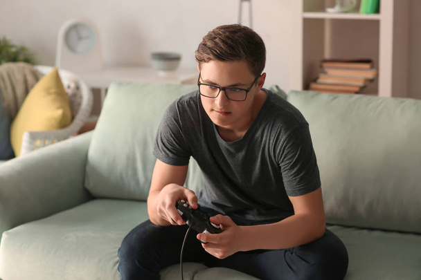 十代の若者は自宅でビデオゲームをプレイ - 写真・画像