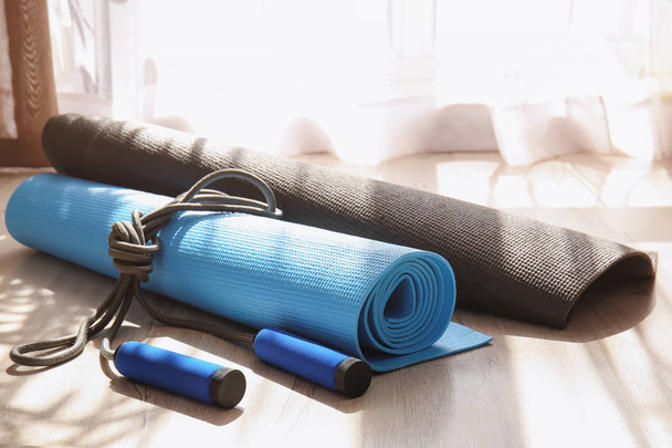 коврики для йоги и скакалка на деревянном полу
 - Фото, изображение