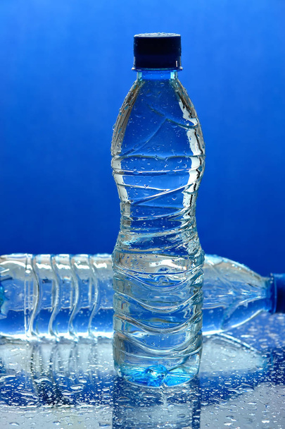 Water bottles on blue background    - 写真・画像