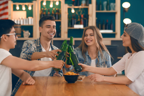 Groep van vrolijke vrienden drinken bier in staaf - Foto, afbeelding