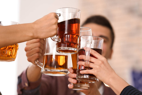 Grupo de amigos batendo copos com cerveja no bar
 - Foto, Imagem