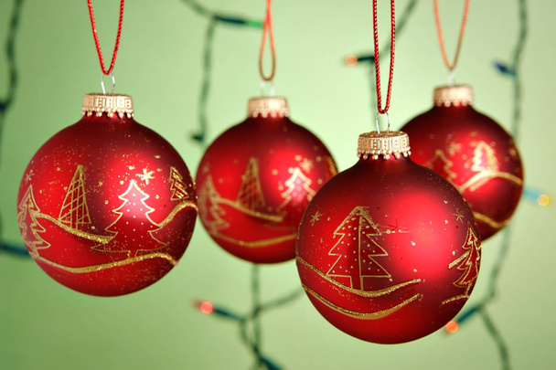Christmas baubles hanging over green background - Photo, Image