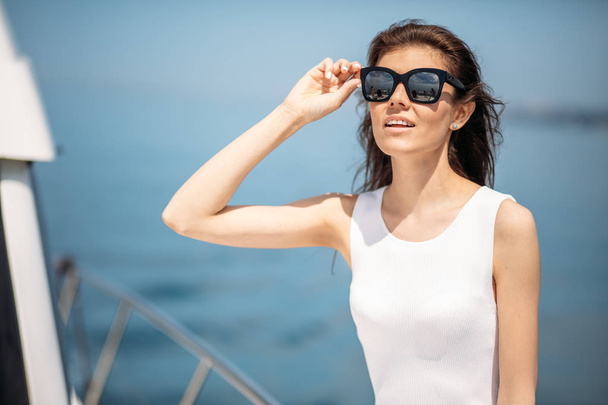 Young, attractive and rich woman having fotossesion on a luxury boat in sea - Photo, Image