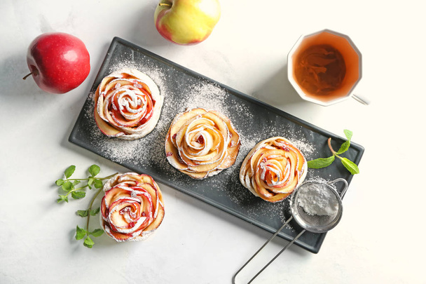 Тарілка зі смачною яблучною випічкою у формі троянди на столі
 - Фото, зображення