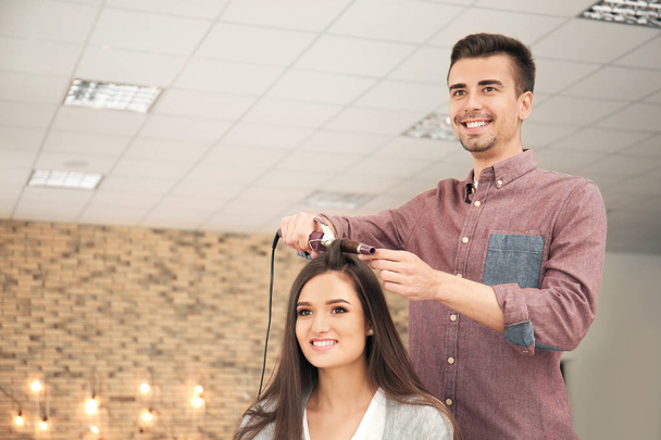 Професійний перукар, що працює з клієнтом в салоні краси
 - Фото, зображення