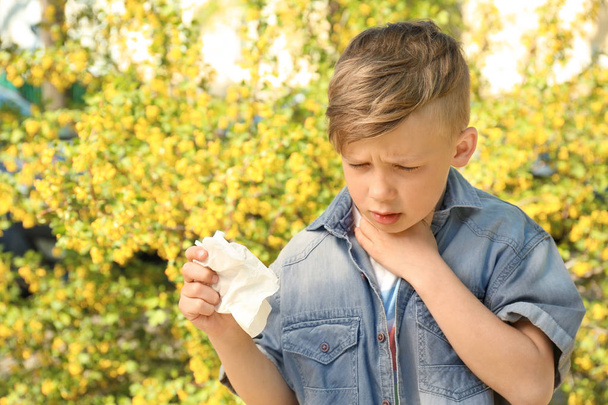 Μικρό αγόρι με μύτη υαλοκαθαριστήρα κοντά ανθίζοντας δέντρο. Αλλεργία έννοια - Φωτογραφία, εικόνα