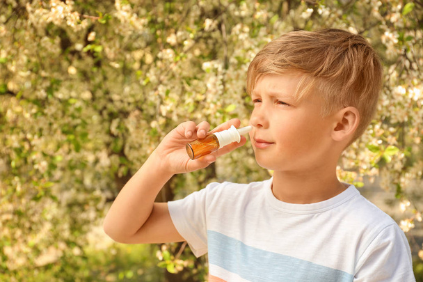 Malý chlapec používat nosní kapky poblíž Kvetoucí strom. Alergie koncept - Fotografie, Obrázek