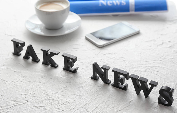 Words FAKE NEWS made of letters on textured table - 写真・画像
