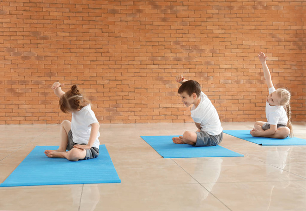 Little children practicing yoga indoors - 写真・画像