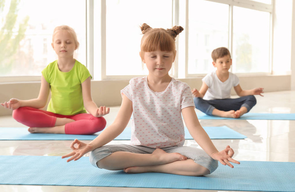 Маленькие дети практикуют йогу в помещении
 - Фото, изображение