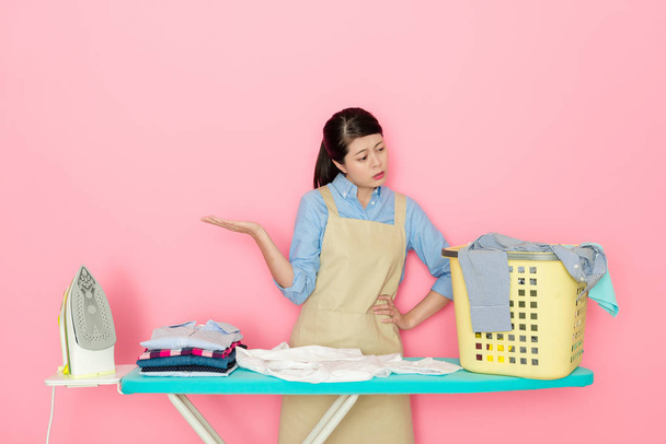 Japonês casa mãe sente cansaço para ver tantas roupas prontas para fazer engomar isolado no fundo rosa
. - Foto, Imagem