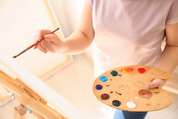 Female artist painting picture in workshop - Fotografie, Obrázek
