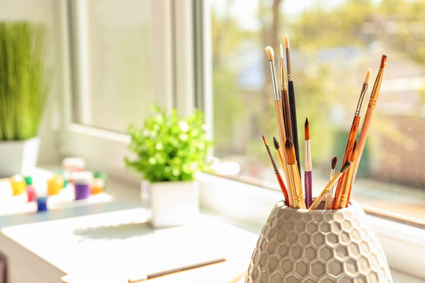 Set of brushes on window sill in artist's workshop - Zdjęcie, obraz