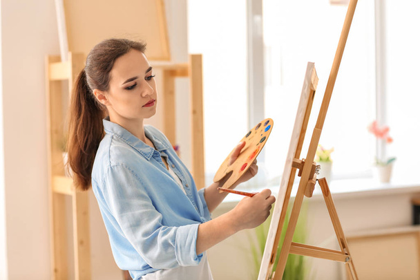 Female artist painting picture in workshop - Photo, Image