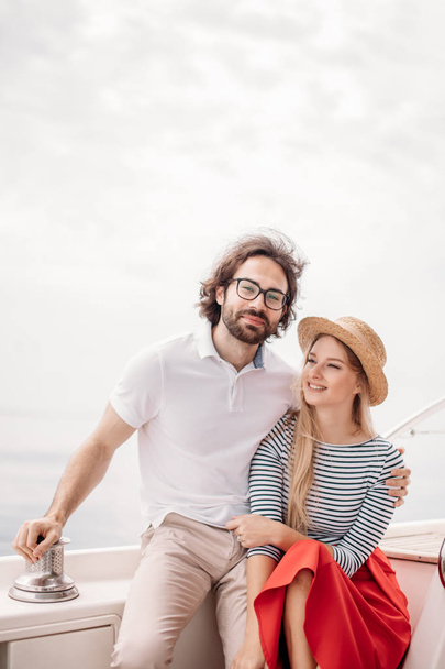 Young beautiful married couple embracing on the yacht on vacation - Photo, image