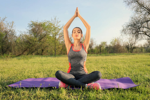 Sportliche junge Frau praktiziert Yoga im Park - Foto, Bild