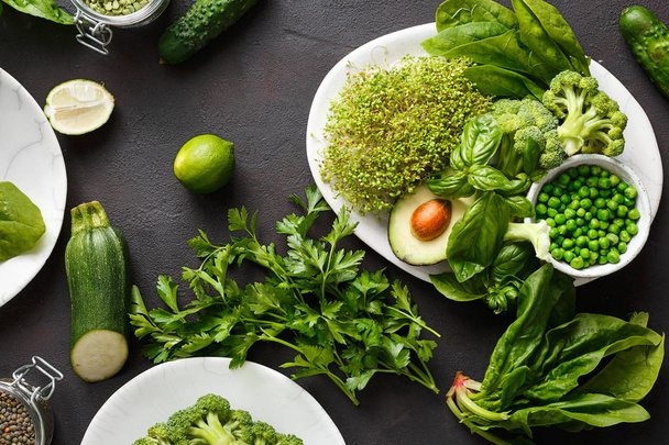 Healthy food clean eating selection source of protein for vegetarians: lucerne, spinach, basil, green peas, avocado, broccoli and green lentils on dark background, top view - Foto, Imagem