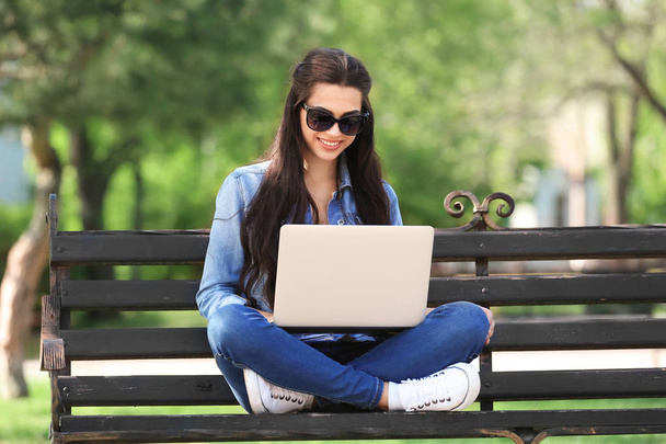 Красивая молодая женщина отдыхает в парке с ноутбуком
 - Фото, изображение
