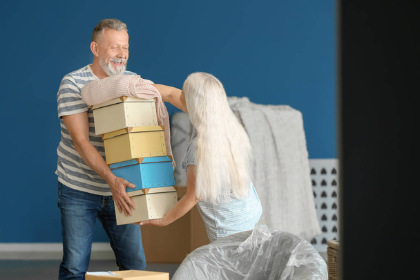Couple mature avec des boîtes de déménagement à la nouvelle maison
 - Photo, image