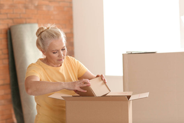 Yeni evde hareketli kutular ile Olgun kadın - Fotoğraf, Görsel