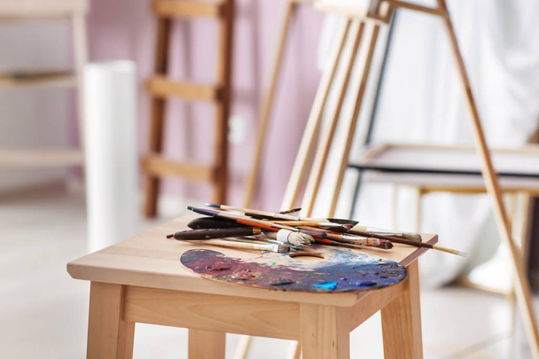 Mesa com ferramentas de pintura e paleta na oficina do artista
 - Foto, Imagem