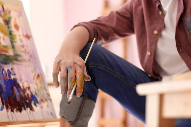 Male artist painting in workshop - Фото, изображение