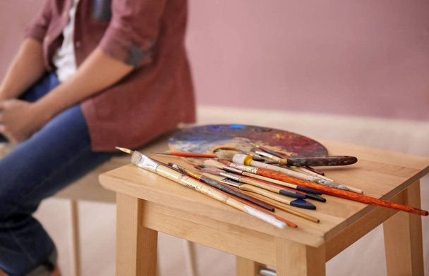 Mesa com ferramentas de pintura e paleta na oficina do artista
 - Foto, Imagem