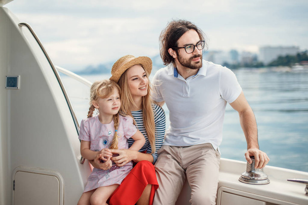 Father, mother and daughter sailing on yacht at the sea - Фото, зображення