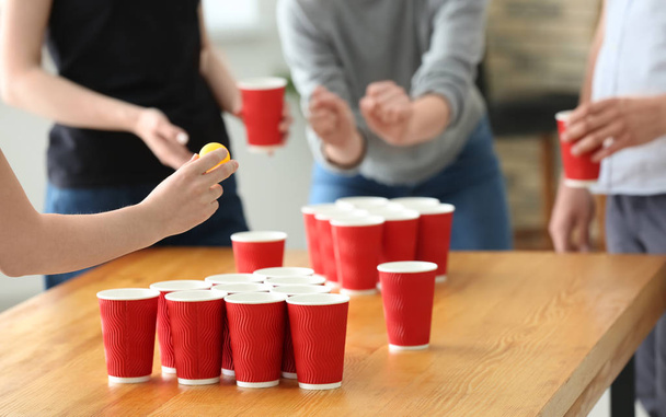 Woman with friends playing beer pong in bar - Photo, Image
