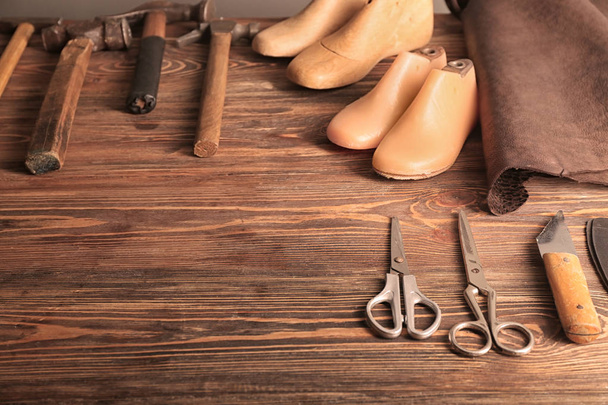 Prawidła do butów z narzędzia rzemieślnicze na drewnianym stole w warsztaty skórzanymi - Zdjęcie, obraz