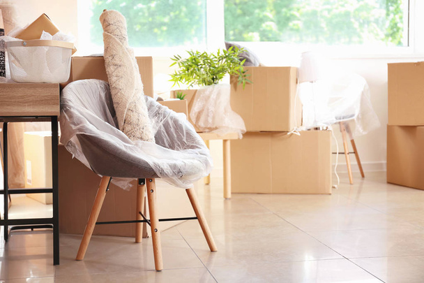 Interior items and packed carton boxes in room. Moving house concept - Photo, Image
