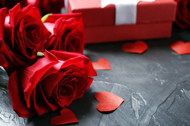 Beautiful roses near gift box on dark table - Φωτογραφία, εικόνα