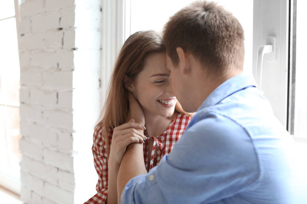 glückliches junges Paar ruht sich am Fenster zu Hause aus - Foto, Bild