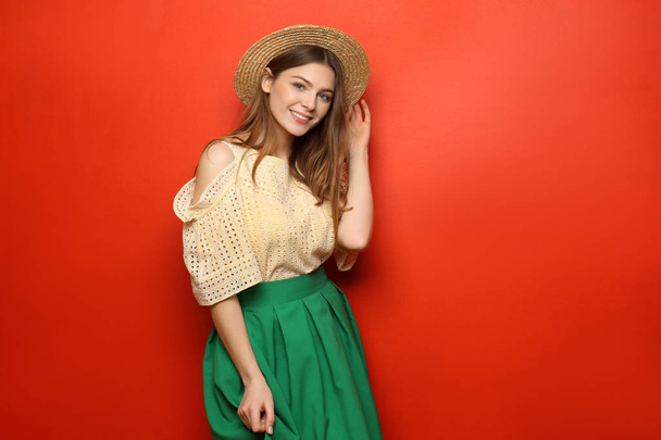 schöne junge Frau mit Hut auf farbigem Hintergrund - Foto, Bild
